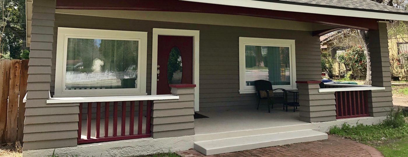 Deep covered porch with tapered columns and a painted railing on an older craftsman bungalow on the westside near downtown Paso Robles, California